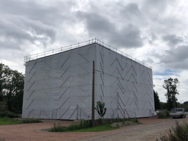 Bâtiment en construction sous bâche blanche