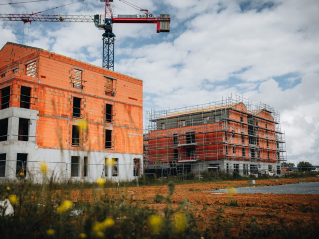 Chantier de construction avec grue et bâtiments en briques.